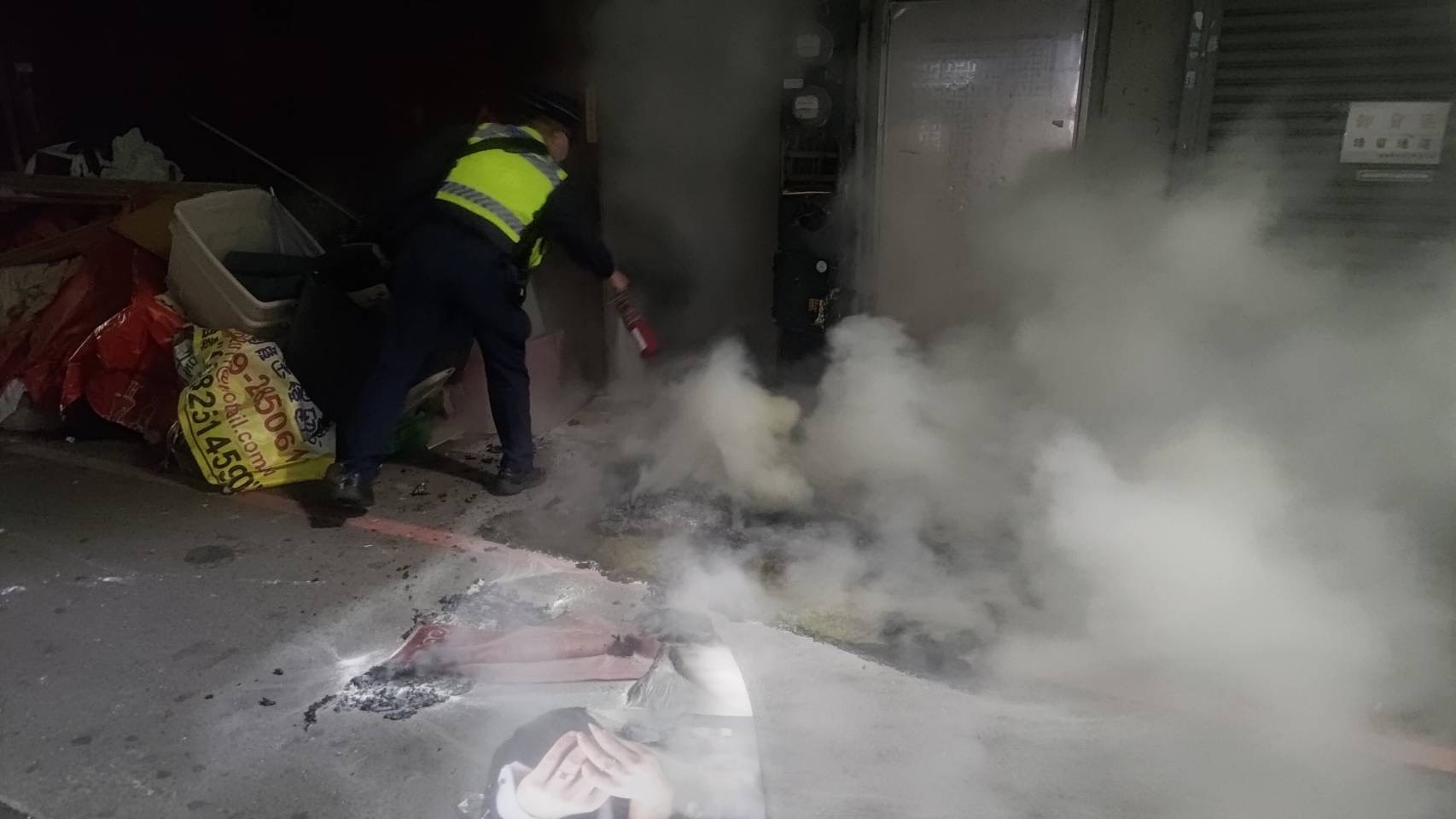 ▲圖說:員警取用隨車滅火器,努力撲滅已經起火燃燒的床墊與遮雨棚雜物 (圖/台中市政府 提供) - 報新聞 Mega News ▲圖說:員警取用隨車滅火器,努力撲滅已經起火燃燒的床墊與遮雨棚雜物 (圖/台中市政府 提供)