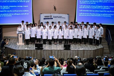 Photo 2: The first cohort of medical students participating in the White Coat Ceremony and taking the Hippocratic Oath